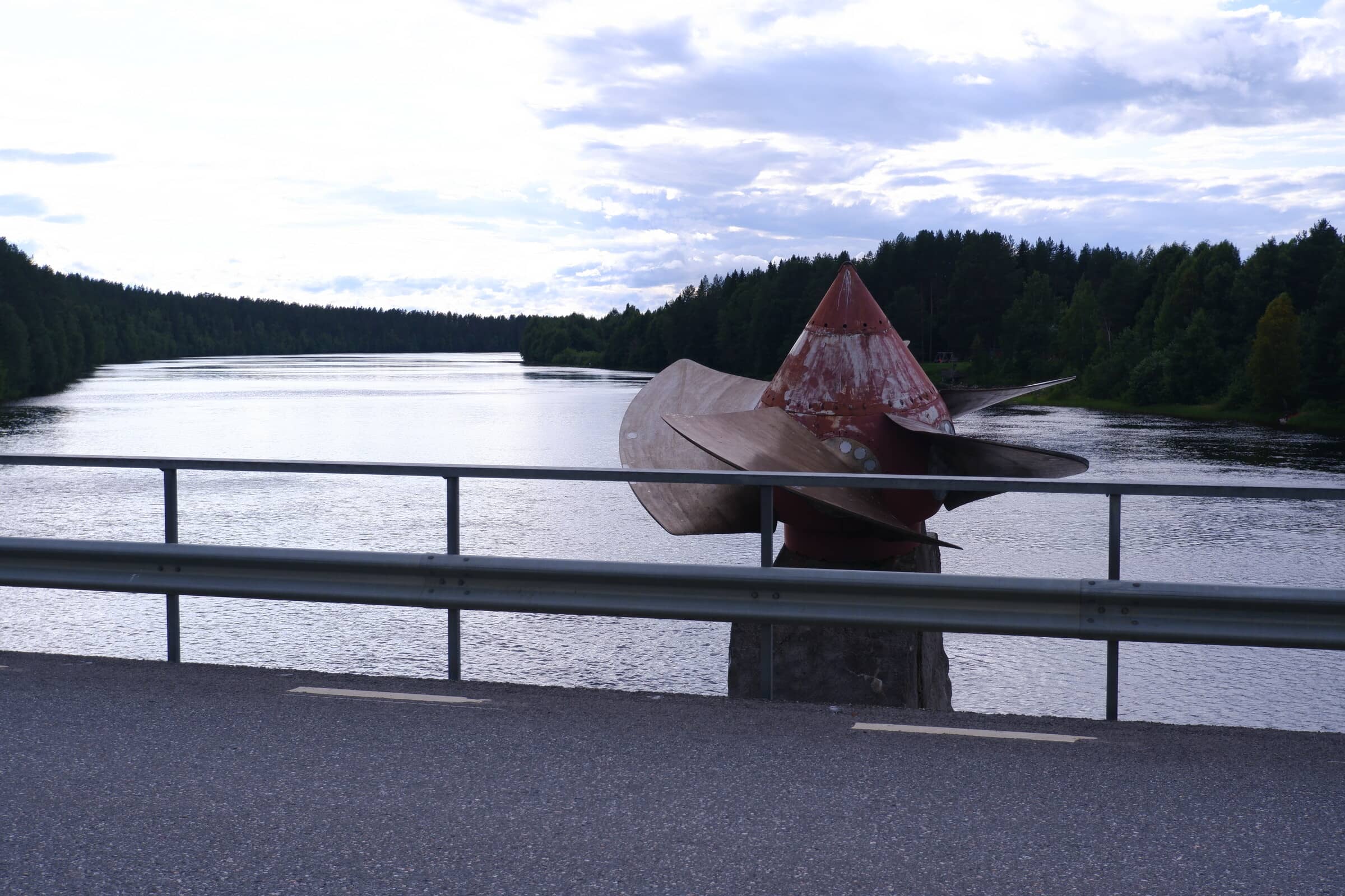 Hydropower turbine placed on a disused bridge pylon in the middle of a river.